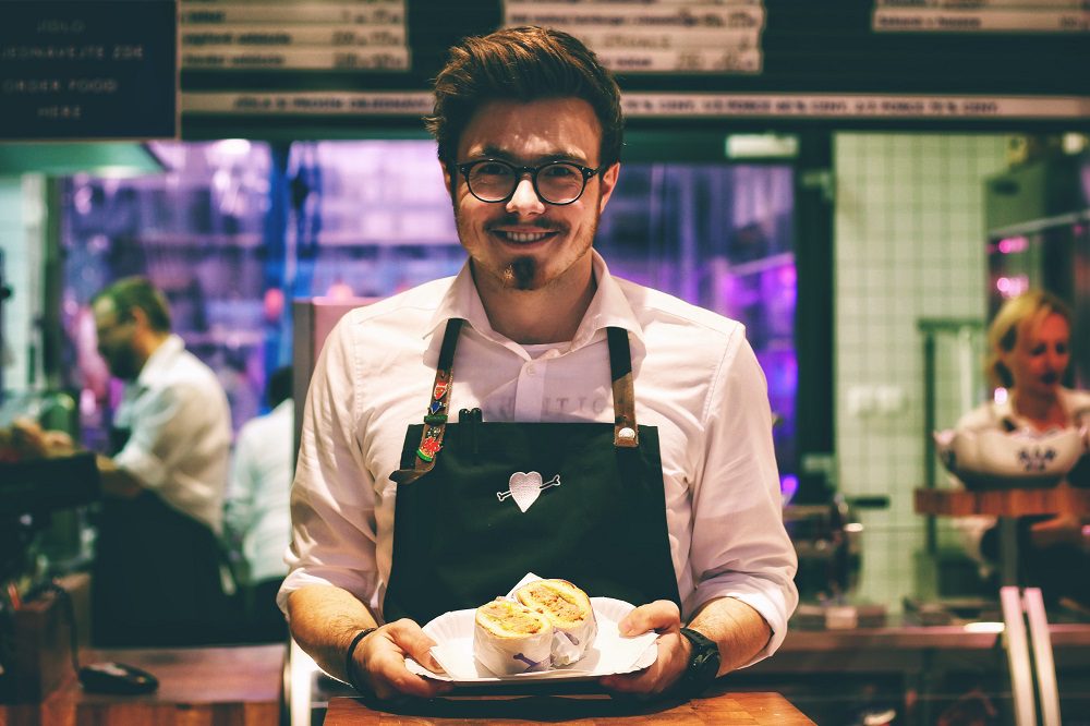 Happy waiter holding plate