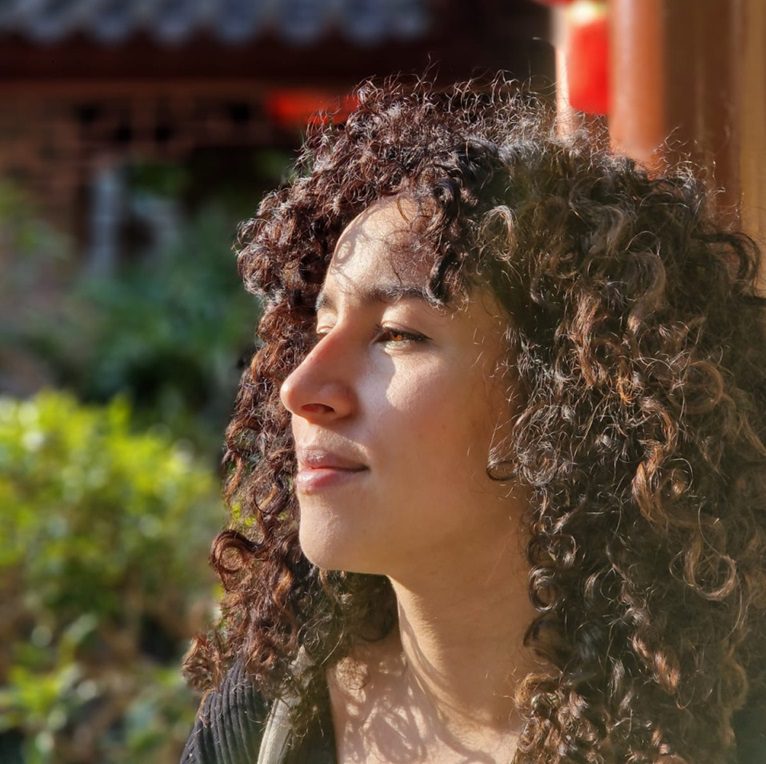 A beautiful woman looking to the left posing for a close up photo