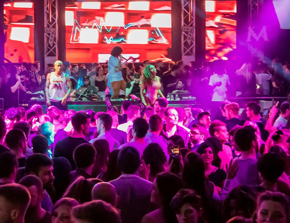 A dance floor packed with a rent-a-crowd audience watching performers